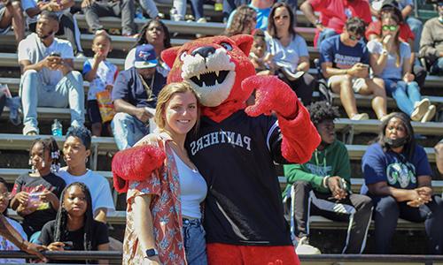 Pouncer the mascot pauses with a fan in the stands during a LaGrange College football game.